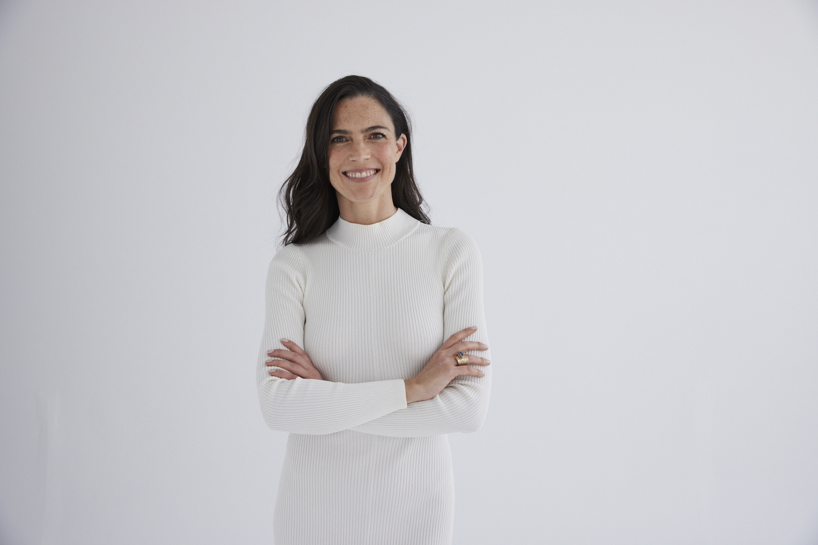Jayne Halikiotis smiling warmly in a cream knit dress, reflecting lived experience and holistic recovery